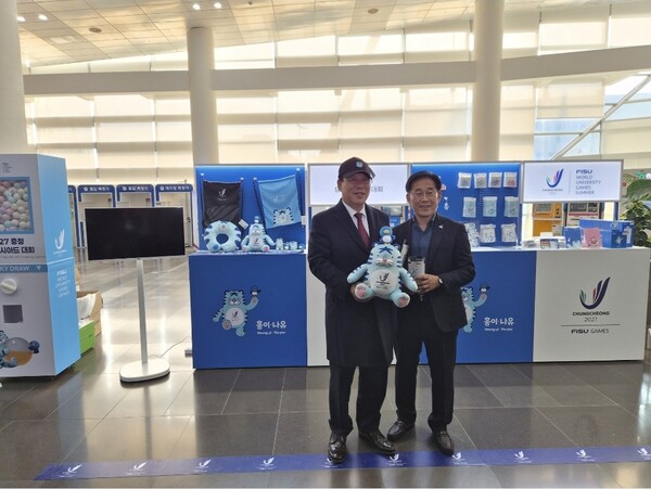 2027 충청 유니버시아드대회 조직위원회가 24일 세종시청 1층 로비에 공식 상품 팝업 부스를 설치하고 20여 종의 굿즈를 선보이는 이벤트를 개최했다. 행사장을 찾은 최민호 세종시장과 조직위 이창섭 부위원장이 굿즈를 살펴보고 있다. [사진=조직위 제공]