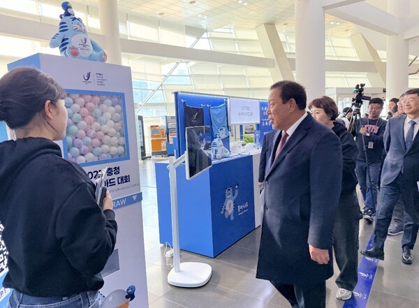 2027 충청 유니버시아드대회 조직위원회가 24일 세종시청 1층 로비에 공식 상품 팝업 부스를 설치하고 20여 종의 굿즈를 선보이는 이벤트를 개최했다. 행사장을 찾은 최민호 세종시장과 조직위 이창섭 부위원장이 굿즈를 살펴보고 있다.[사진=조직위 제공]